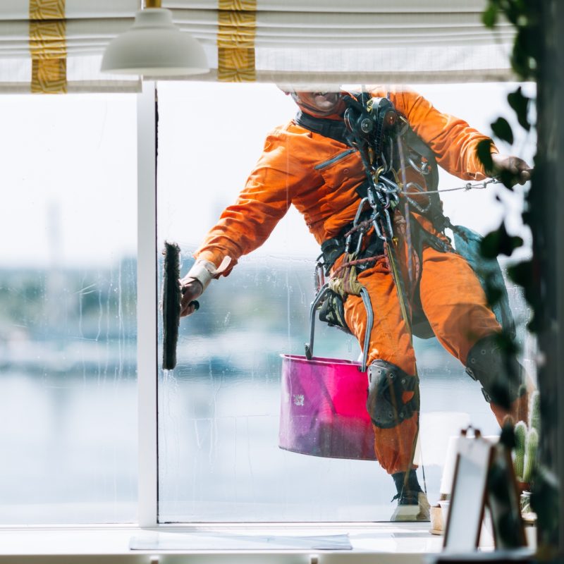 Industrial climbes is washing glass on the facade of a skyscraper, inside view