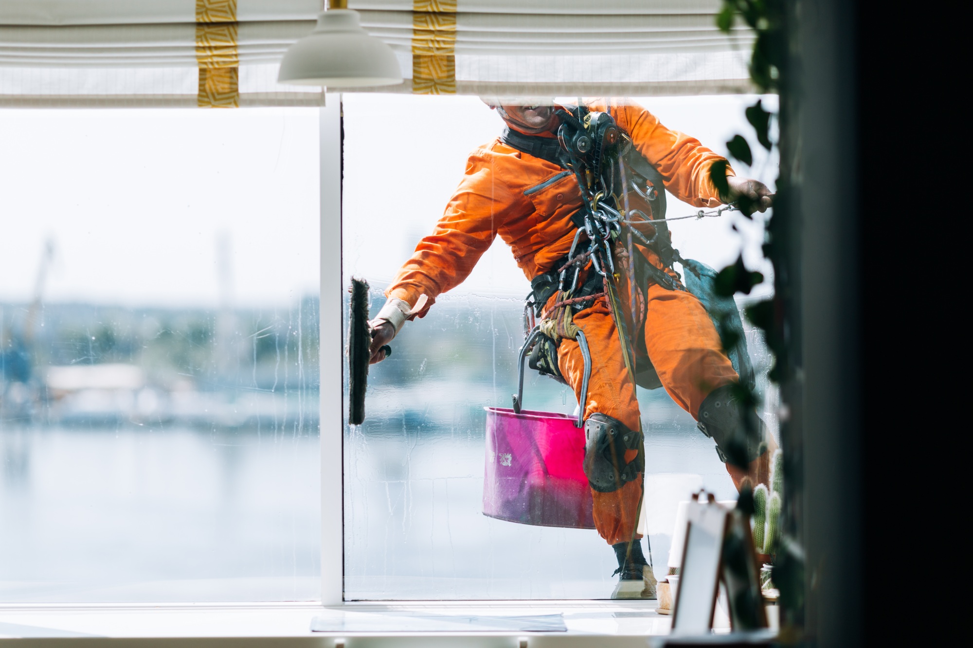 Industrial climbes is washing glass on the facade of a skyscraper, inside view